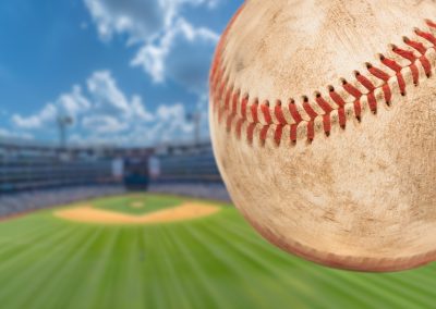 Baseball,Flying,Through,The,Air,With,Stadium,In,The,Background.