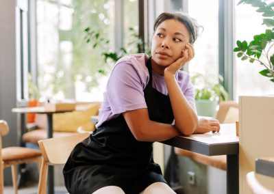 Young,Waitress,Is,Sitting,Alone,At,A,Table,In,A