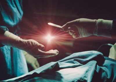 Doctor,Operating,Patient,In,Hospital,Sending,Surgical,Blade,With,Light