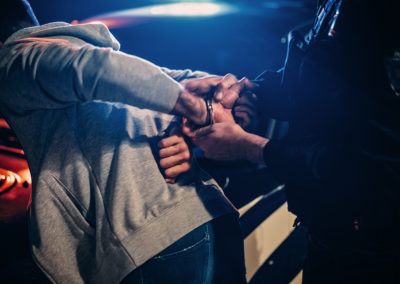 Male,Policeman,Forcing,A,Compliant,Civilian,On,The,Hood,Of