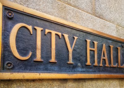 Exterior,Sign,That,Reads,”city,Hall”,In,Brass,Lettering.,Close