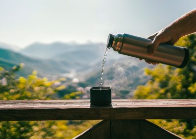 A,Man,Pours,Boiling,Water,From,A,Thermos,At,Sunrise