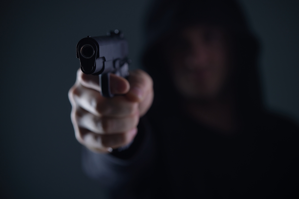 Robber,With,Gun,Aiming,Into,Camera.,Man,In,Hood,Threatens