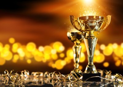 Champion,Golden,Trophy,On,Wood,Table,With,Blur,Spot,Lights