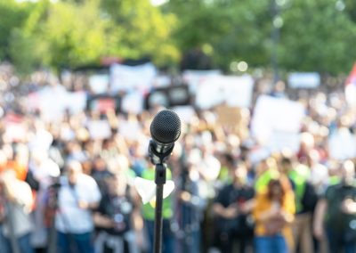 Protest,Or,Public,Demonstration,,Focus,On,Microphone,,Blurred,Crowd,Of