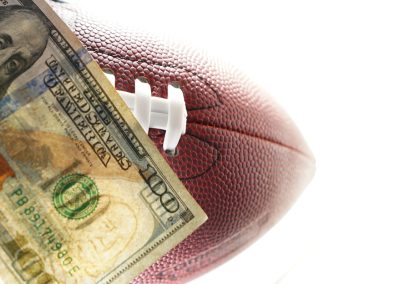 Hundred,Dollar,Bill,On,An,American,Football,,On,White,Background