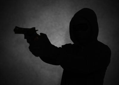 Mysterious,Man,Wearing,Black,Hoodie,Holding,A,Pistol,,Shooting,With