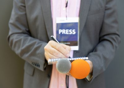 Journalist,At,Press,Conference,Or,Media,Event,,Holding,Microphone,,Writing