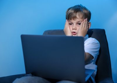 Cyber,Danger.,Frightened,Little,Boy,Using,Laptop,On,Blue,Background