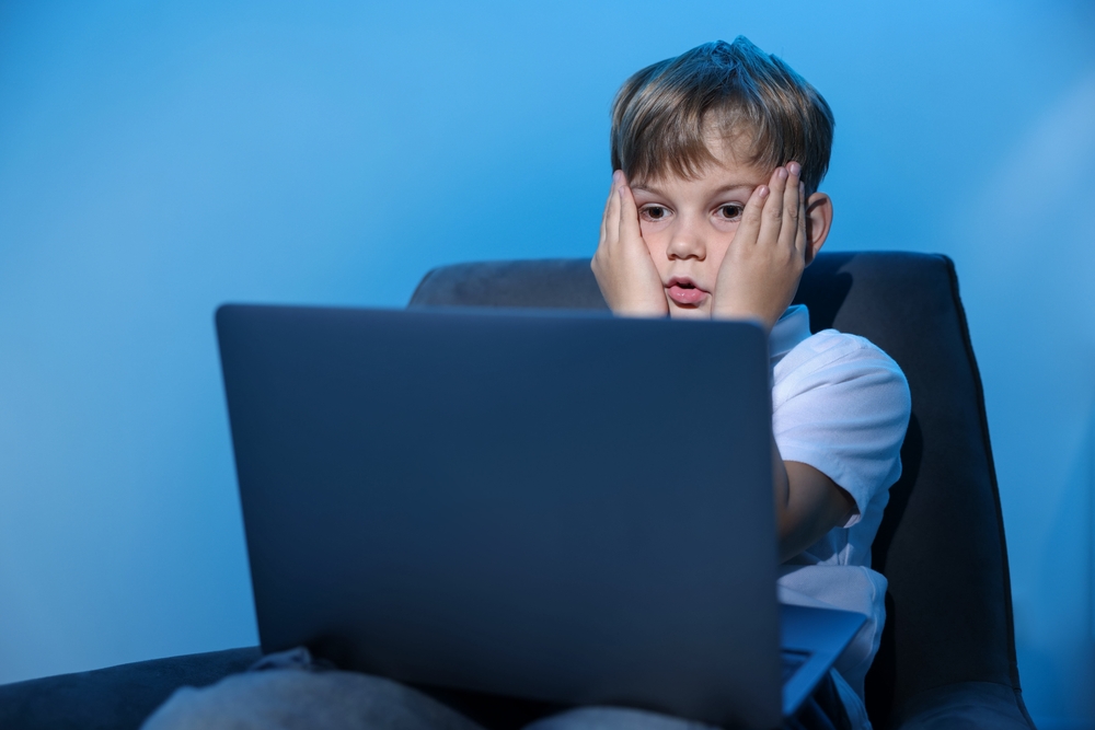Cyber,Danger.,Frightened,Little,Boy,Using,Laptop,On,Blue,Background