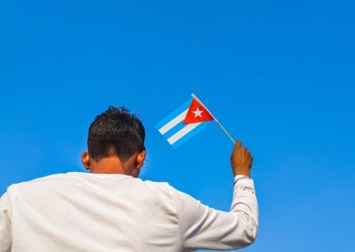 ICE Just Put 170 Cuban Criminals on a Plane and Sent Them Home While Democrats Called It Cruel Boy,Holding,Cuba,Flag,Against,Clear,Blue,Sky.,Man,Hand