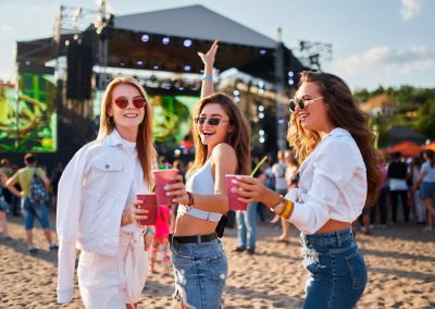 Women,Toast,With,Cocktails,At,Sunny,Beachside,Music,Event,,Enjoying