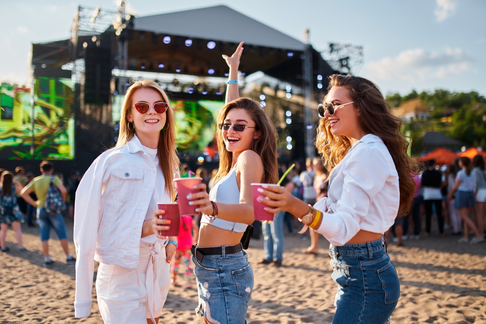 Women,Toast,With,Cocktails,At,Sunny,Beachside,Music,Event,,Enjoying