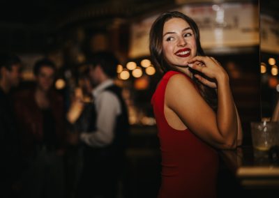 A,Stylish,Woman,In,A,Red,Dress,Smiles,Warmly,At