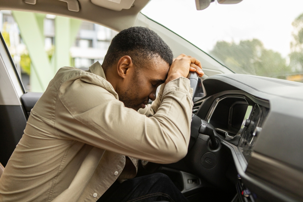 African,American,Man,Sleeping,In,A,Car,,Resting,Head,On