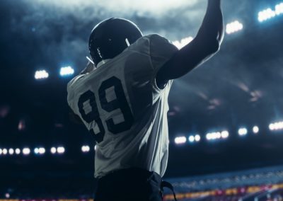 Black,Football,Player,Celebrating,Victory,In,Stadium,,Wearing,A,White