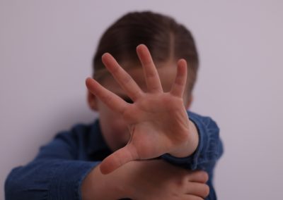 Child,Abuse.,Girl,Making,Stop,Gesture,Near,Grey,Wall,,Selective