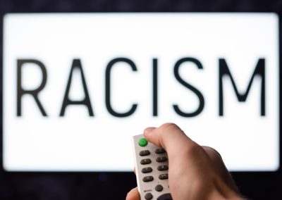 Racist,Male,With,Remote,Controller,Turns,On,A,Tv,Set