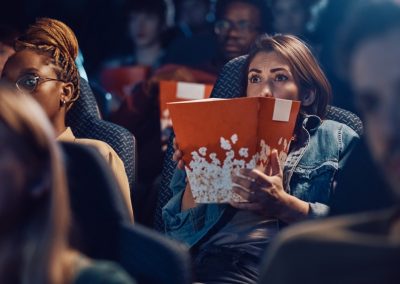 Young,Frightened,Woman,Watching,Scary,Movie,At,The,Cinema.