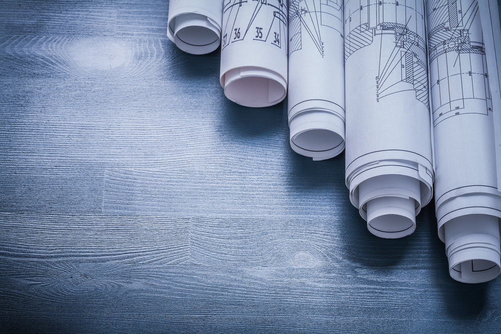 Copyspace,Image,Rolls,Of,Blueprints,On,Blue,Board.