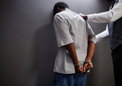 Back,View,Of,Young,Black,Man,Arrested,Standing,By,Wall