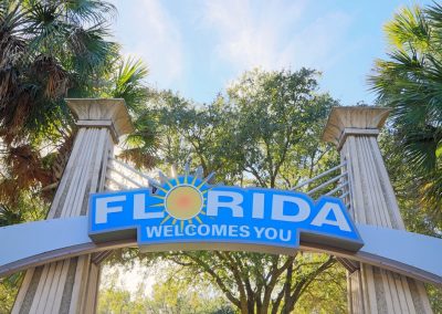 “florida,Welcomes,You”,Sign,Against,Palm,Trees,And,Blue,Sky