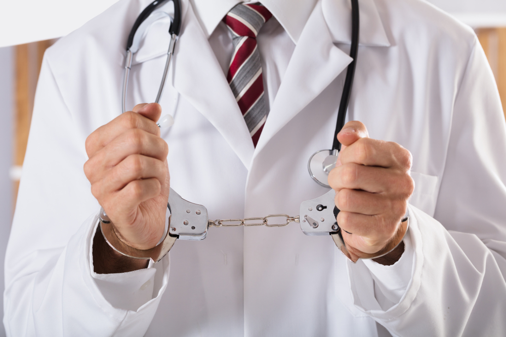 Close-up,Of,Arrested,Doctor’s,Hand,With,Handcuffs