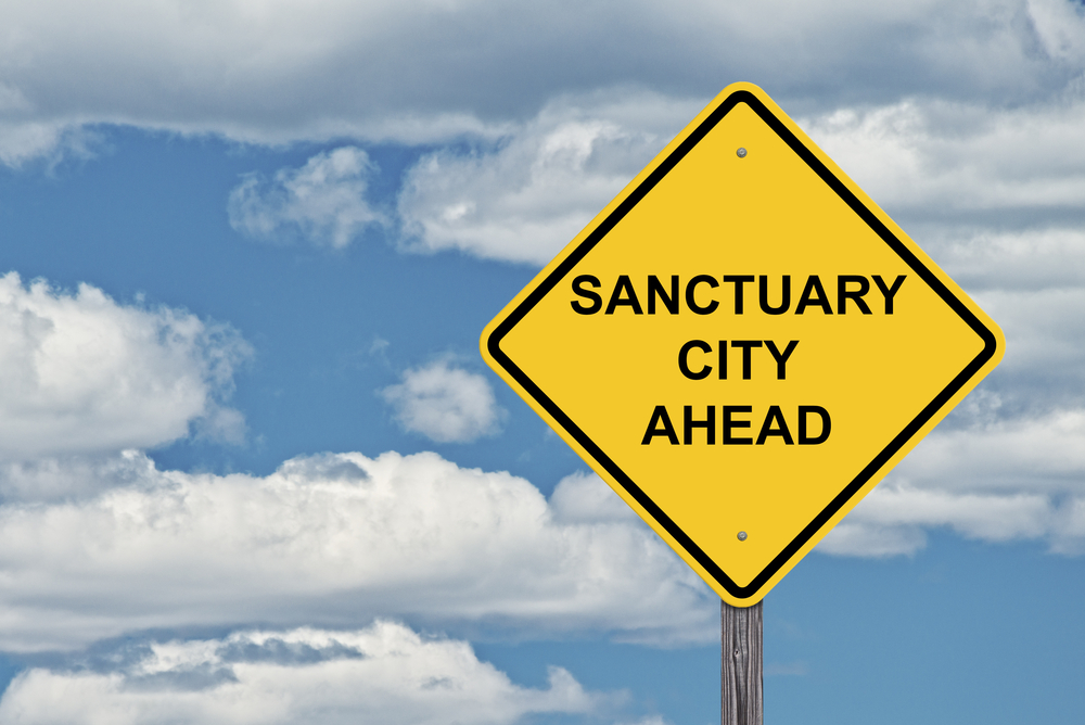 Caution,Sign,Blue,Sky,Background,-,Sanctuary,City,Ahead