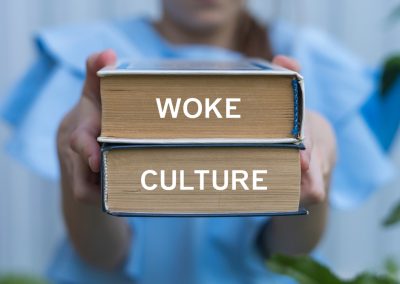 Young,Girl,Holding,Two,Books,With,Inscription,On,Side:,Woke