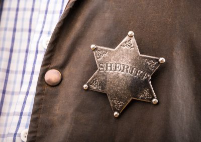 Polk County’s Sheriff Found the Man Who Attacked a 77 Year Old Woman Still in the Shower Next Door Close,Up,Of,Sheriff,Badge,When,On,His,Coat,Duster