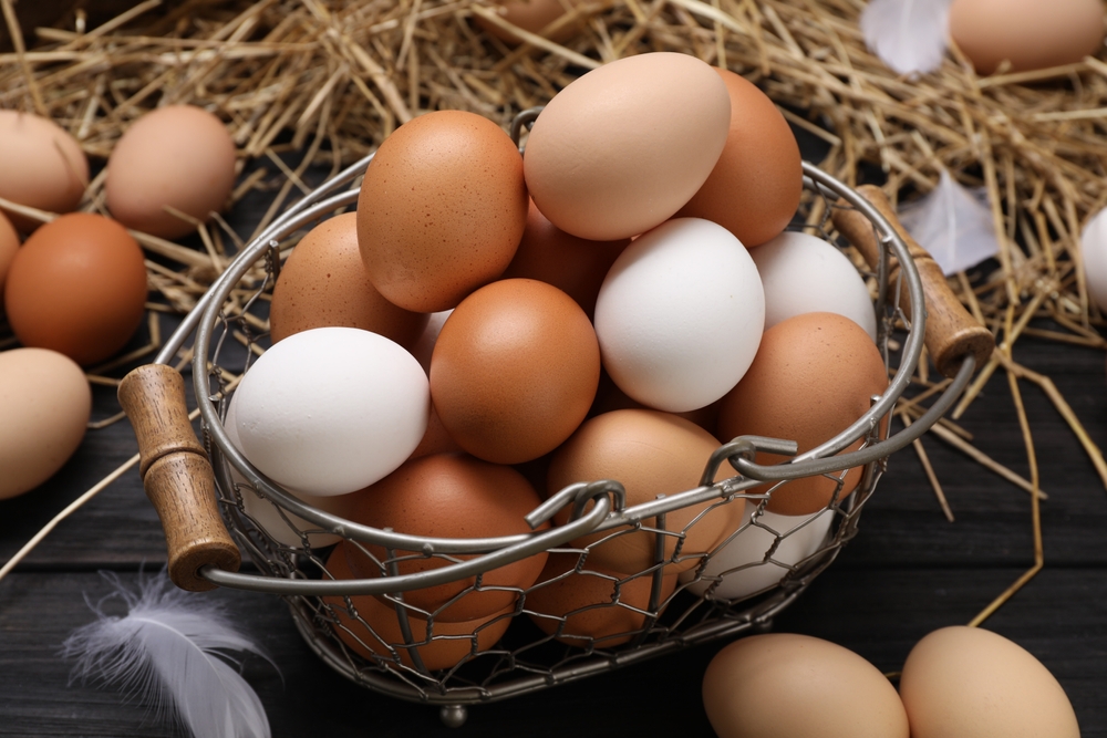 Fresh,Chicken,Eggs,And,Dried,Straw,On,Black,Wooden,Table,